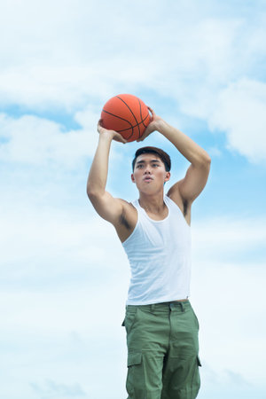 Copy-spaced image of a basketball player passing the ball over skyの写真素材