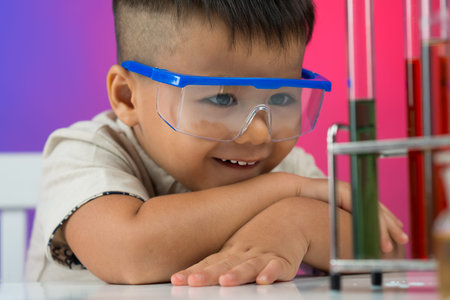 Close-up image of a little boy looking at the chemical substance with interest in the labの写真素材