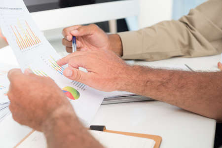 Cropped image of businesspeople making a strategy analysis on the foregroundの写真素材