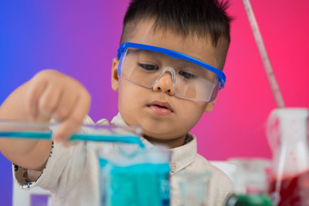 Image of a little boy in the chemical laboratory on the foreground