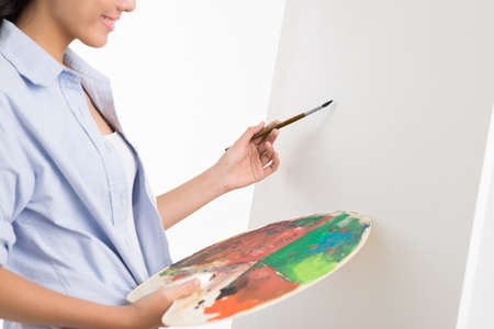 Cropped image of a painter making first strokes on the canvas on the foregroundの写真素材