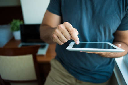 Cropped image of a man touching a tablet on the foregroundの写真素材