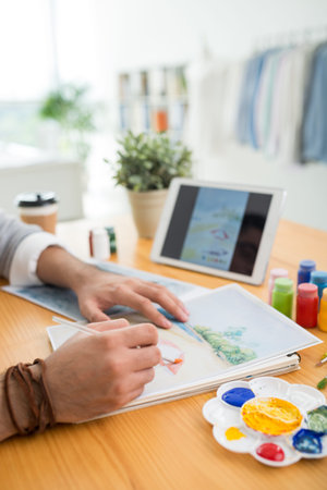Hands of creative man copying landscape from digital tablet