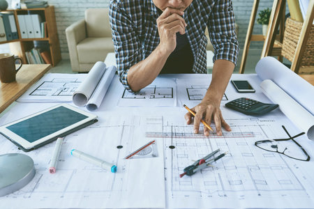 Cropped image of architect working with construction plans