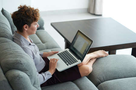 Business lady sitting on comfortable sofa and planning her dayの写真素材