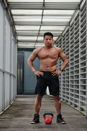 Full-length portrait of bodybuilder working out with kerttlebellの写真素材