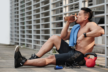Sportsman resting and drinking water after trainingの写真素材
