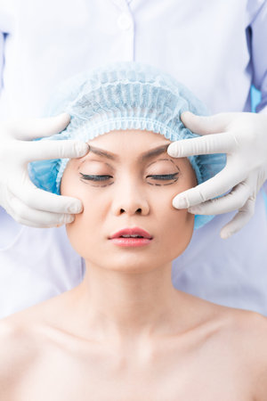 Cosmetic surgeon preparing to operate on a womanの写真素材