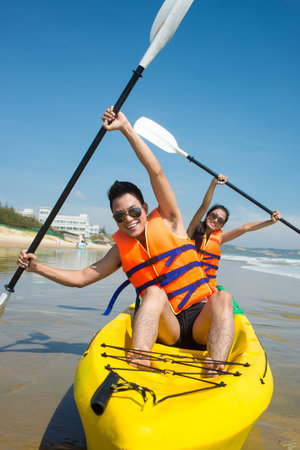 Young couple posing in kayak with oarsの写真素材
