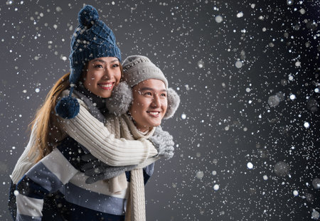 Copy-spaced image of a young couple in-love piggybacking in winter seasonの写真素材