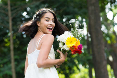 Portrait of a cheerful young woman with a spring bunch outdoorsの写真素材
