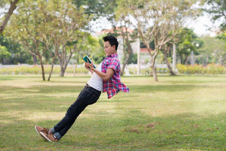 Boy leaning against the air with a bookの写真素材