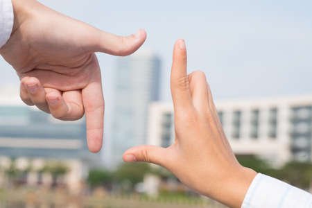 Closeup image of human hands focusing his hands on the building on the foregroundの写真素材
