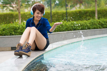 Copy-spaced image of a cheerful girl with headphones having fun in the parkの写真素材
