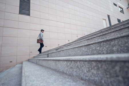 Stylish man going up the stairs, view from the sideの写真素材