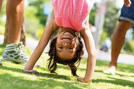 Cute little girl standing on her hands in the backyard