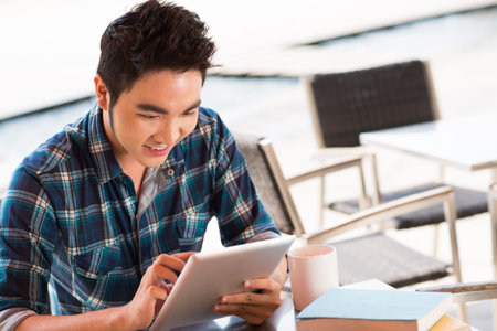 Closeup image of a student chatting by the Internet with somebody during the break on the foreground