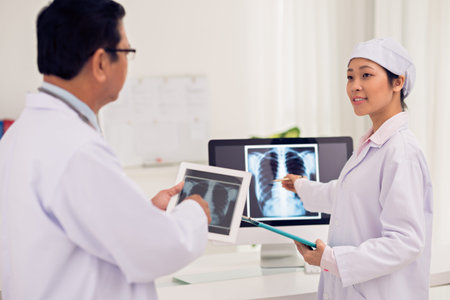 Asian intern showing doctor the x-ray of lungs on the screen of the computer