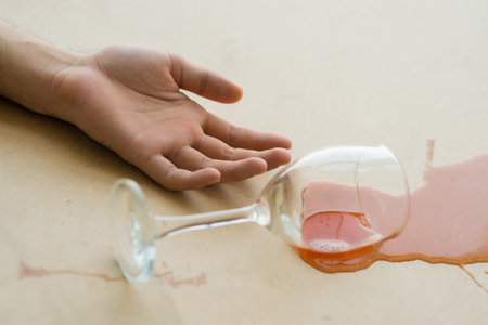 Passive hand and wineglass on the floorの写真素材
