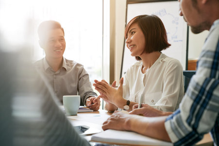 Pretty young female entrepreneur talking to her employees at meeting