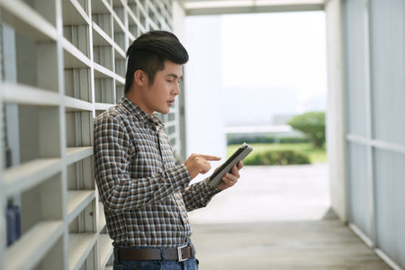 Young man standing with digital tablet