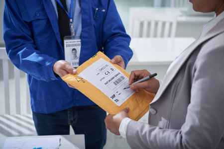 Business lady writing shipping address on packageの写真素材
