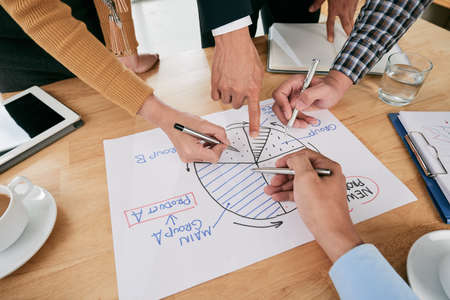 Hands of business people pointing at circle diagramの写真素材