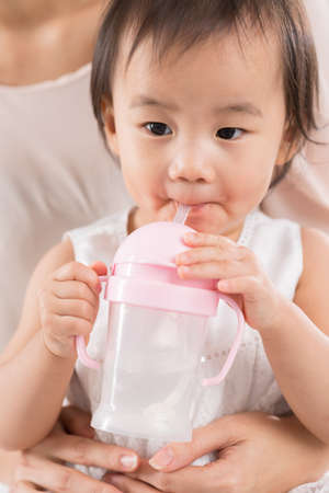 Chinese toddler drinking from feeding bottleの写真素材