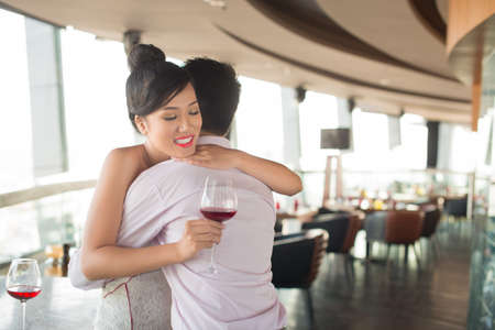 Young couple hugging at a cafe in the sign of deep loveの写真素材