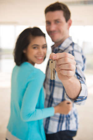 Young family holding keys from their new houseの写真素材
