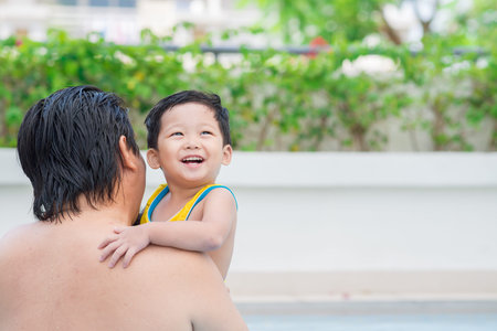 Man in swimming pool with a boy