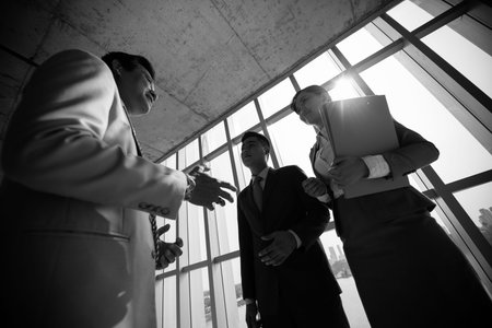 Angle view of business colleagues talking at the end of business meeting