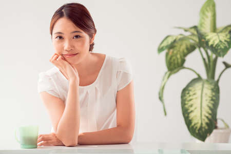 Portrait of Asian smiling woman leaning on her handの写真素材