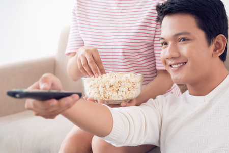 Close-up of Asian man changing channels