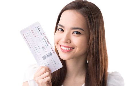 Happy Asian woman with a boarding pass