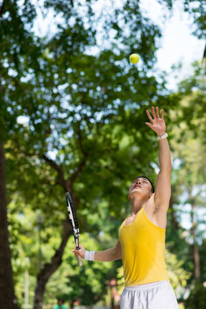 Tennis player serving ball