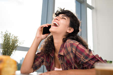Portrait of laughing woman talking on the phoneの写真素材