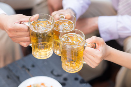 Close-up of three people drinking cold beerの写真素材