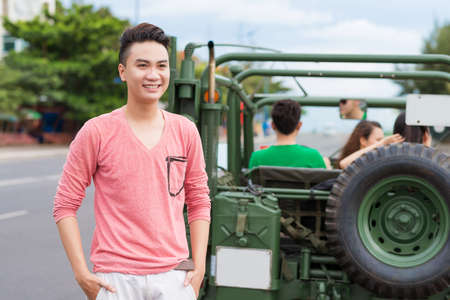 Portrait of Vietnamese young man with an off-road car in backgroundの写真素材