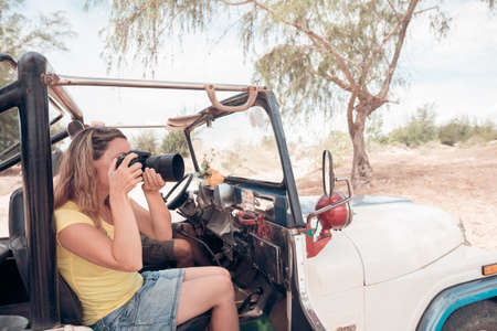 Woman taking photo from the off-road vehicleの写真素材