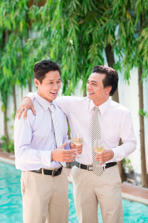 Two men joking and drinking champagneの写真素材