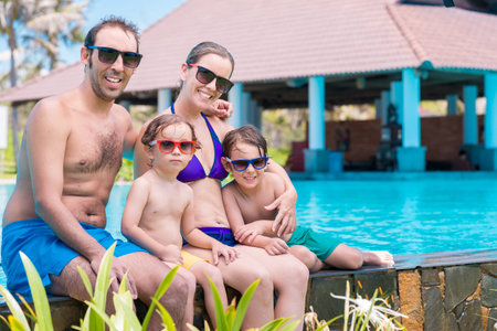 Family in sunglasses and bathing suits bonding together