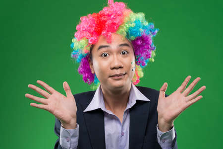 Portrait of an amazed man in a colorful wigの写真素材