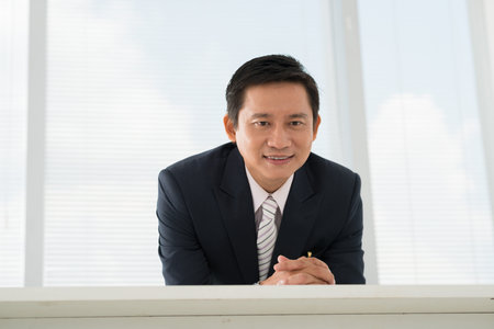 Asian entrepreneur supervising the work of his employeesの写真素材