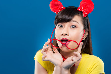 Portrait of surprised Asian girl holding plastic glasses