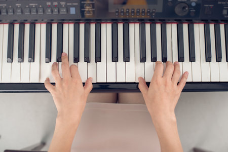 Female piano player, view from the top, body and buttons of the piano were digitally modifiedの写真素材