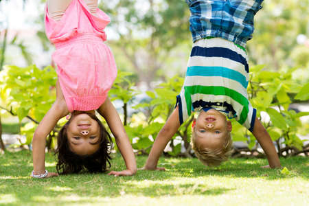 Two playful children standing on their hands in the parkの写真素材
