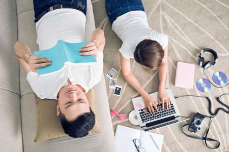Young couple spending their time at home, view from the topの写真素材