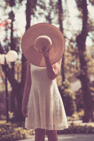 Portrait of woman covering her face with a straw hatの写真素材