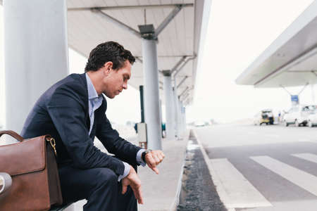 Elegant man waiting for taxi at the airportの写真素材